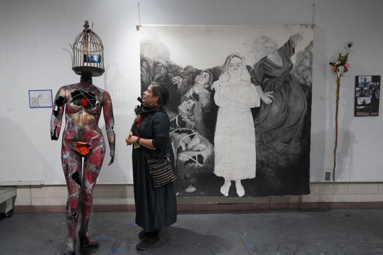 Stella Arbelaez explained to the public on Friday how her divorce inspired her to pursue her master's in Fine Arts at UCF. The art she looks at is called "The Broken Woman," which reflects how broken she felt after the divorce. The cell phone represents the addiction to social media she developed when her daughter left. Marisol Merced